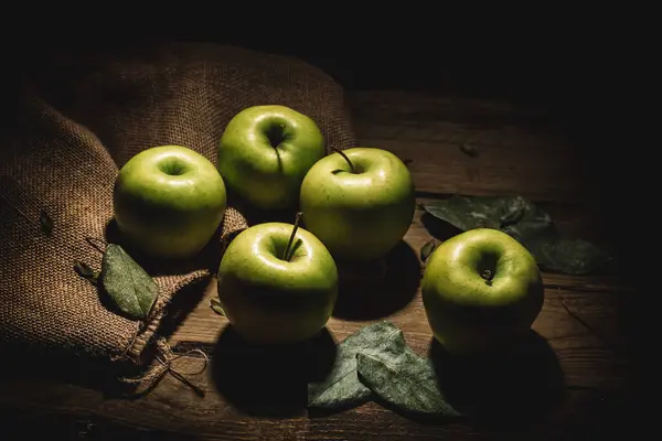 Bir çuval yeşil elma ve kırsal ahşap..