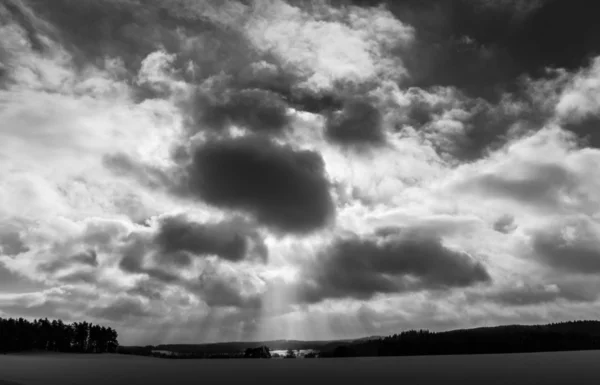 Cielo dramático con rayos de sol y nubes pesadas y paisaje Foto en blanco y negro —  Fotos de Stock