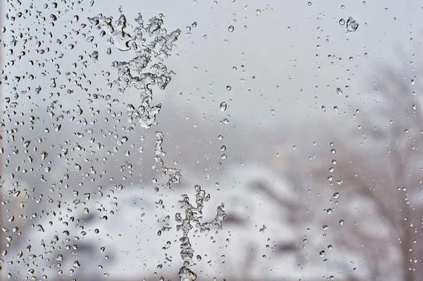 Frozen window glass after the winter thaw. — Stock Photo, Image