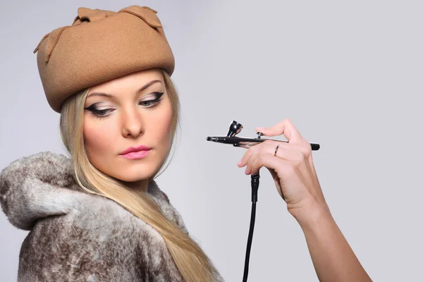 Fashionable portrait of a girl model with hand airbrush. — Stock Photo, Image