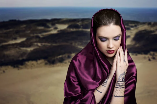 Mujer rezando en el desierto con mehendi en las manos y usando el hijab — Foto de Stock