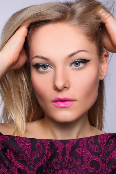 Porträtt av en vacker blond kvinna med make-up pil — Stockfoto