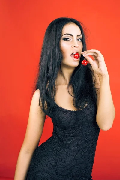 Όμορφη σέξι μελαχρινή γυναίκα σε κόκκινο φόντο — Φωτογραφία Αρχείου