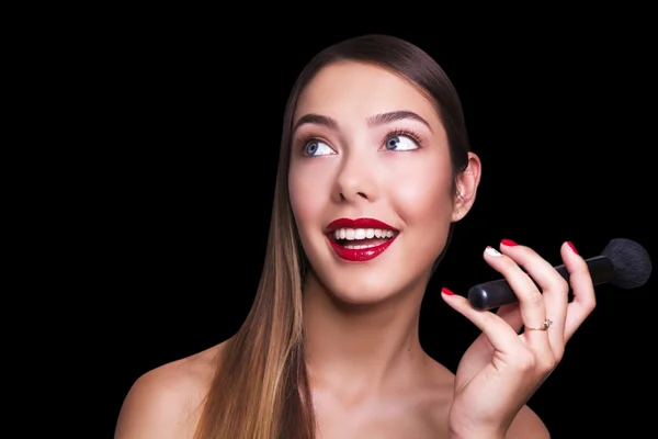 Close portrait of beautiful girl making make up. Isolated on black background. Copy space. — Stock Photo, Image