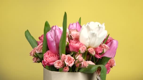 Bellissimo bouquet di fiori con rose e tulipani, su giallo, rotazione — Video Stock