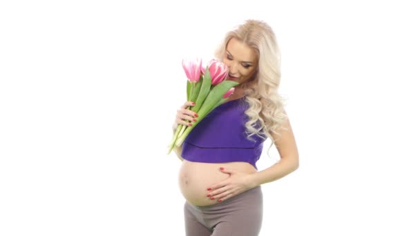 Pregnant beautiful blonde girl smelling a bouquet of tulips, white — Stock Video