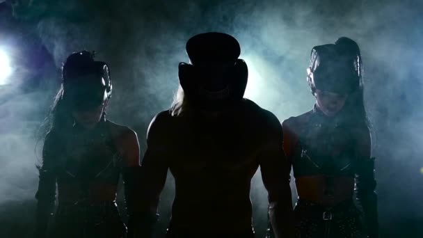 Эротическое шоу мужчины и двух женщин в дыму, вверх головой, на черной, замедленной съемке — стоковое видео