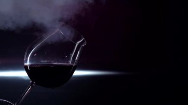 Bardak kırmızı şarap, siyah, backlights slowmotion Sigara