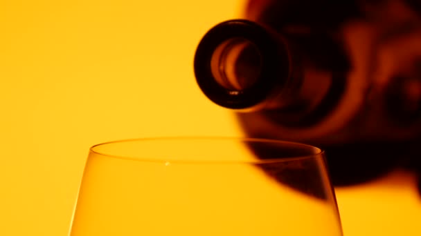 El vino tinto se vierte en una copa, amarillo, primer plano, cámara lenta — Vídeos de Stock