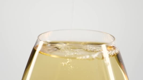 Vino bianco versato in bicchiere pieno, bianco, primo piano, rallentamento — Video Stock