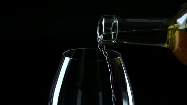 Vinho branco sendo derramado em um copo de vinho, preto, câmera lenta, close-up — Vídeo de Stock