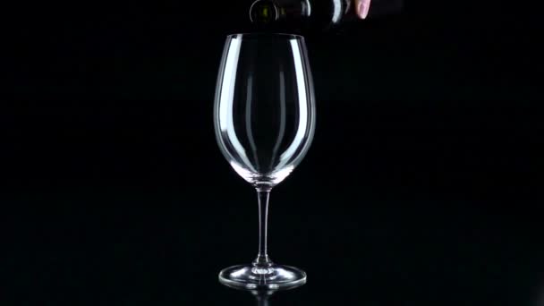 Sklo v němž sommelier nalévá červené víno, černá, silueta, slowmotion, záběr