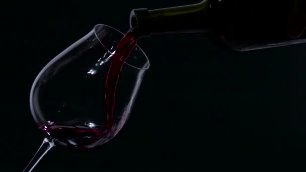 Kırmızı şarap closeup slowmotion, siyah, cam üzerinde sıçrama — Stok video