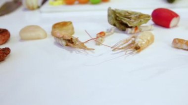 Ham ahtapot ve çiğ deniz tarağı beyaz masada, cam sola, closeup taşır