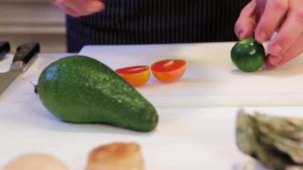 Cook corta meio tomate verde, cam se move para a direita, close-up — Vídeo de Stock