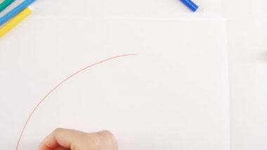 Beyaz kağıt üzerine farklı keçeli kalem kullanarak gökkuşağı çizim kadın