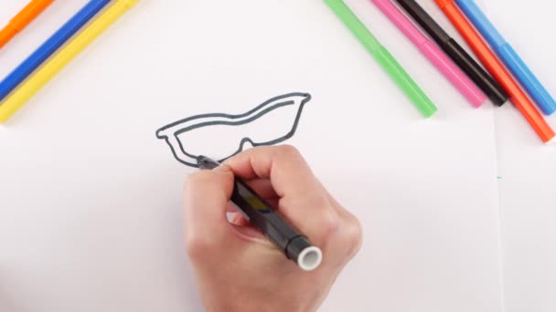 Femme dessinant les lunettes à l'aide d'un stylo feutre noir sur papier blanc, laps de temps — Video