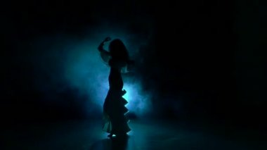 Güzel genç egzotik dansöz kalçalarını sallayarak, siyah, yavaş hareket, siluet, duman