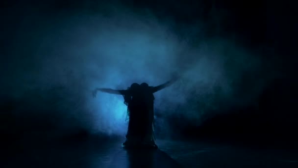 Exotic belly dancer woman starts dance in dark, shadow, smoke, silhouette — Stock Video