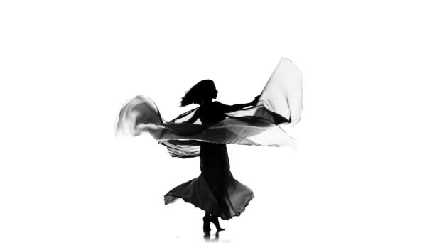 Όμορφη νεαρή εξωτική χορεύτρια της κοιλιάς τινάζει τα ισχία της, χρησιμοποιεί φτερά, σε λευκό, αργή κίνηση, σιλουέτα — Αρχείο Βίντεο