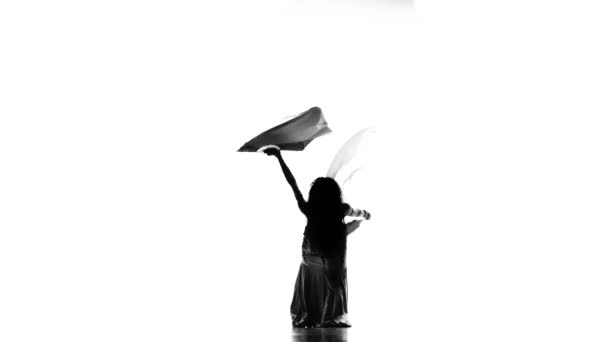 Exotické břišní tanečnicí začíná tanec s fanoušky na bílý, silueta - Stock záběr