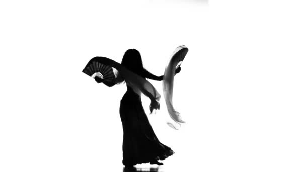 Slanke exotische buikdanseres meisje begint dans met fans op wit, silhouet — Stockvideo