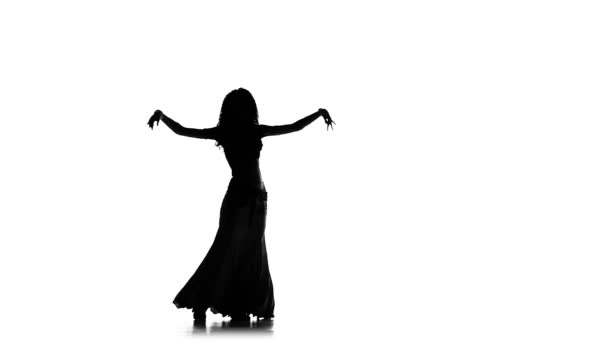 Όμορφη νεαρή εξωτική χορεύτρια της κοιλιάς κουνώντας τους γοφούς της, σε λευκό, αργή κίνηση, σιλουέτα — Αρχείο Βίντεο