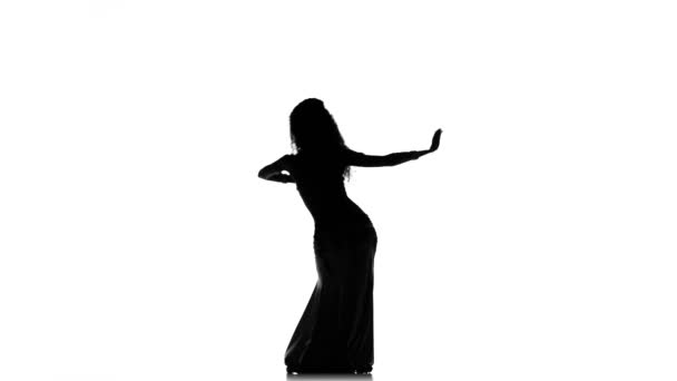 Talentosa menina dançarina barriga exótica de cabelos longos começa a dançar no branco, silhueta — Vídeo de Stock