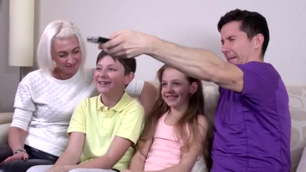 Счастливая большая семья смотрит телевизор дома в гостиной — стоковое видео