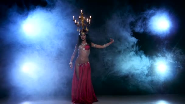 Atraktivní břišní tanečnice tančí s svíčky na hlavu, černé, kouřit — Stock video