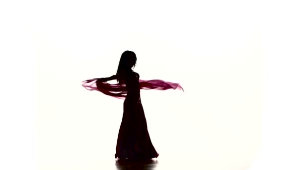 Αρκετά νεαρή γυναίκα που χορεύει χορό της κοιλιάς με χρωματιστά σάλι, σε λευκό, αργή κίνηση — Αρχείο Βίντεο