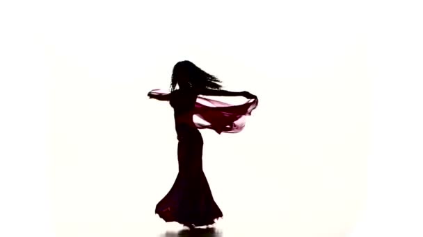 Ganska ung flicka dansa magdans med färgad sjal, på vit, ultrarapid — Stockvideo