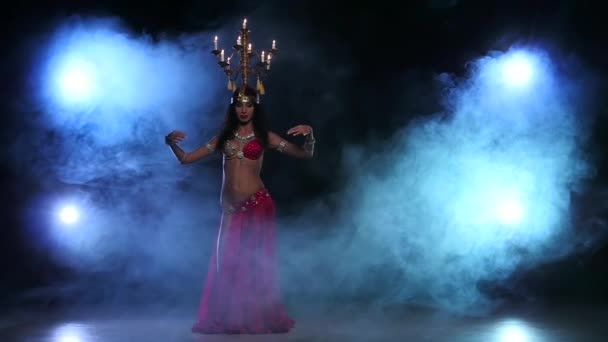 Привлекательная танцовщица живота продолжает танцевать со свечами на голове, черная, дымовая, замедленная съемка — стоковое видео