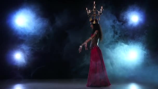 Belly dancer starts dancing with candles, her head, black, smoke, slow motion — ストック動画