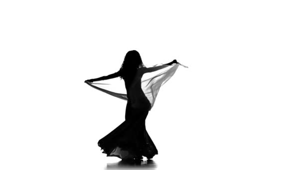 Hübsche junge Frau tanzt Bauchtanz mit Schal, Silhouette, auf weißem Grund, Zeitlupe — Stockvideo