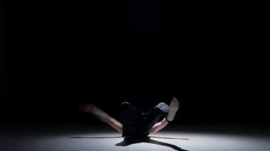 Young blonde dancer man starts dancing breakdance on black