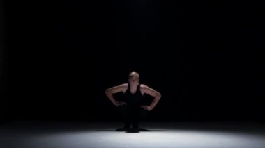 Young blonde dancer man continue dancing breakdance on black