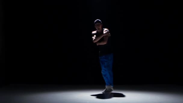 Молодой танцор танцует брейк-данс на черном — стоковое видео