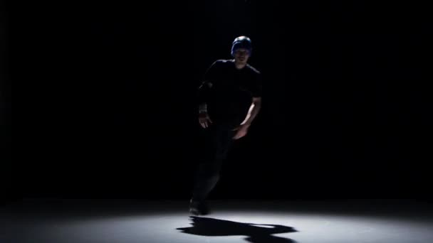 Dancer man in hat starts dancing breakdance on black — Stok video