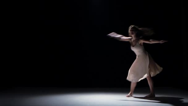 Jeune femme danseuse dansant danse contemporaine, sautant et faisant une scission, sur noir, ombre — Video