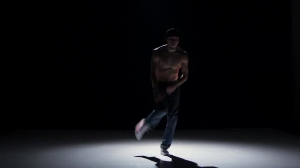 Breakdance dancer in yellow suit with naked torso dance on black, shadow — Stock Video