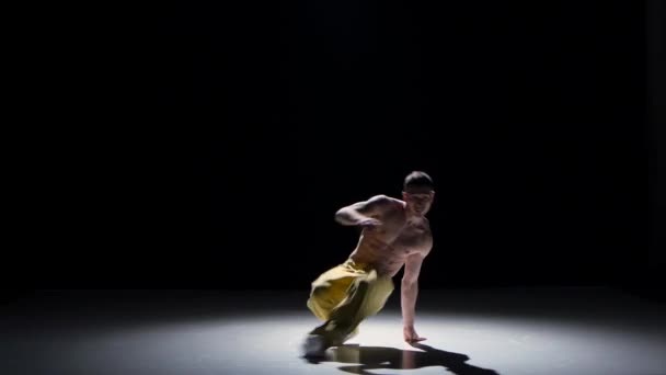 Брейкданс блондинка танцовщица с голым туловищем танцует, делая флип на черный, тень — стоковое видео