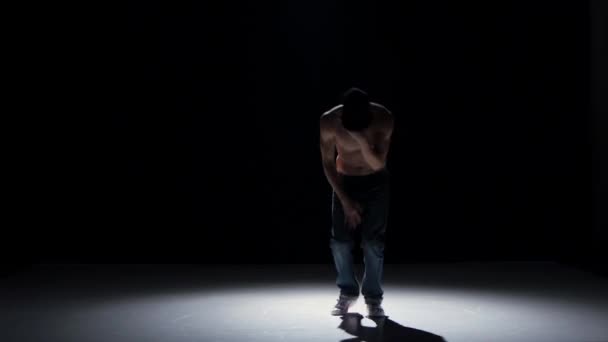 Breakdance danser man in gele pak met naakte torso dans op zwart, schaduw — Stockvideo