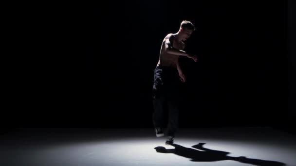 Breakdance danser man met naakte torso begint dans, op zwarte, schaduw — Stockvideo