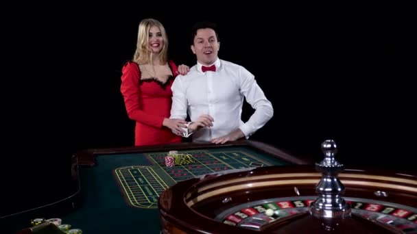 La pareja que juega a la ruleta está ansiosa por ganar en la casa de apuestas. Negro — Vídeos de Stock