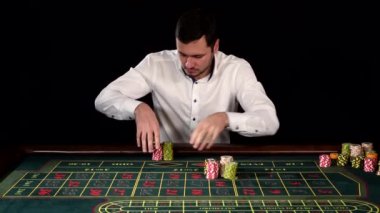Handsome guy puts a bet in the casino. Black