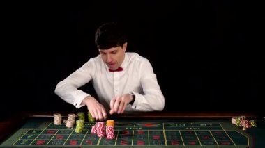 Young guy in the casino at the gaming table. Black