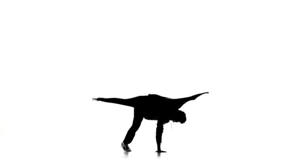 Танцор танцует брейк-данс профессионально движется, белый, силуэт, замедленная съемка — стоковое видео