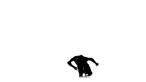Мужчина танцует брейк-данс профессионально движется и поворачивается, белый, силуэт, замедленная съемка — стоковое видео