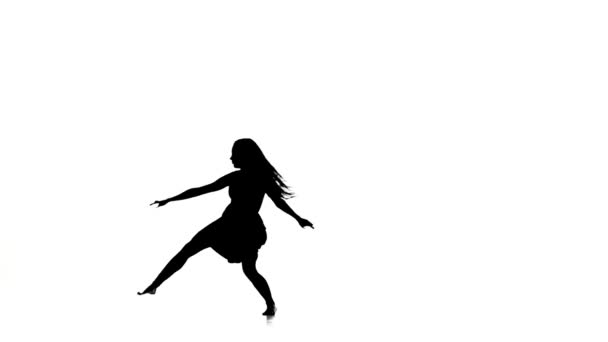 Slim woman dancer dancing contemporary dance and jumps, on white, silhouette, slow motion